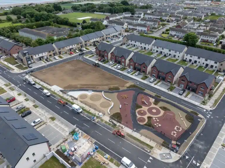 Oblique aerial photograph of a new residential housing estate in Ireland, showing homes, playground and coastline